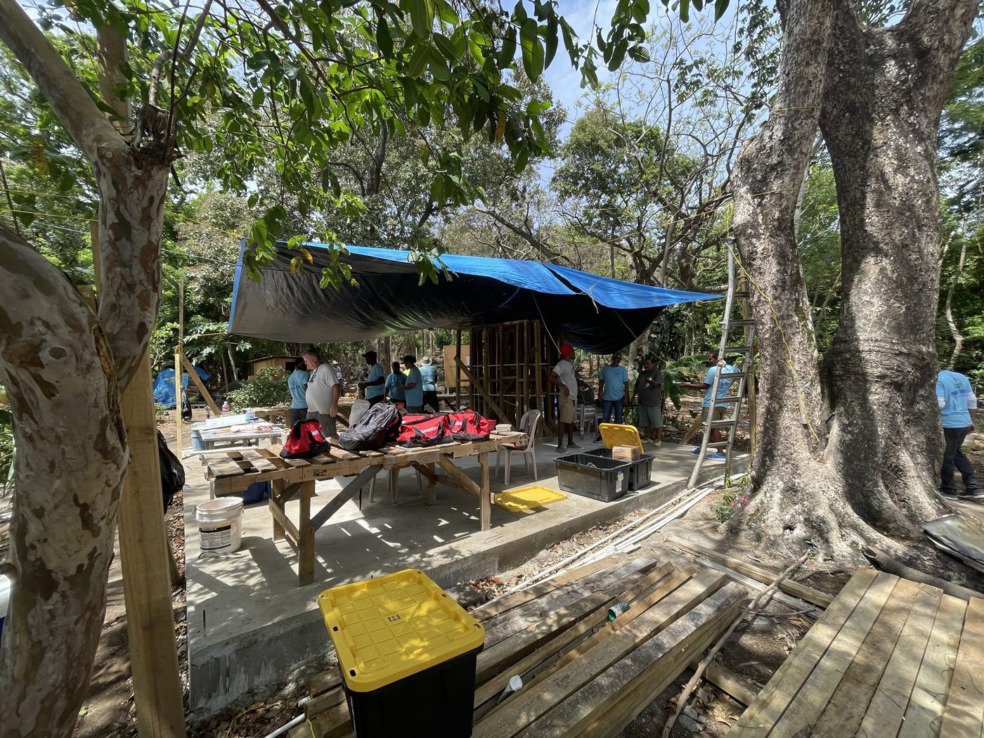 RVT students working under a blue tarp on the original slab — Sandy Bay campus 2022