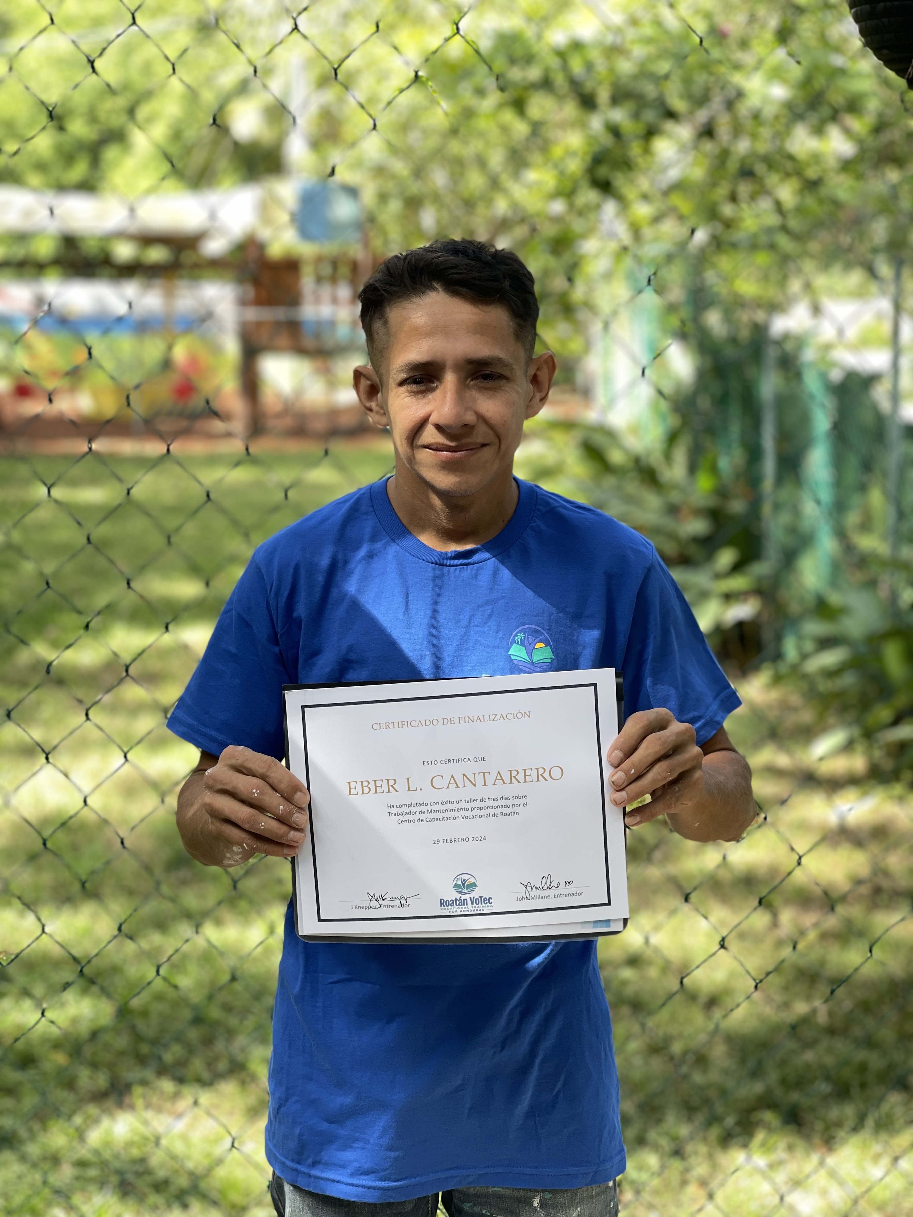 Eber L. Cantarero holding his RVT welding certificate at graduation in Roatán, Honduras