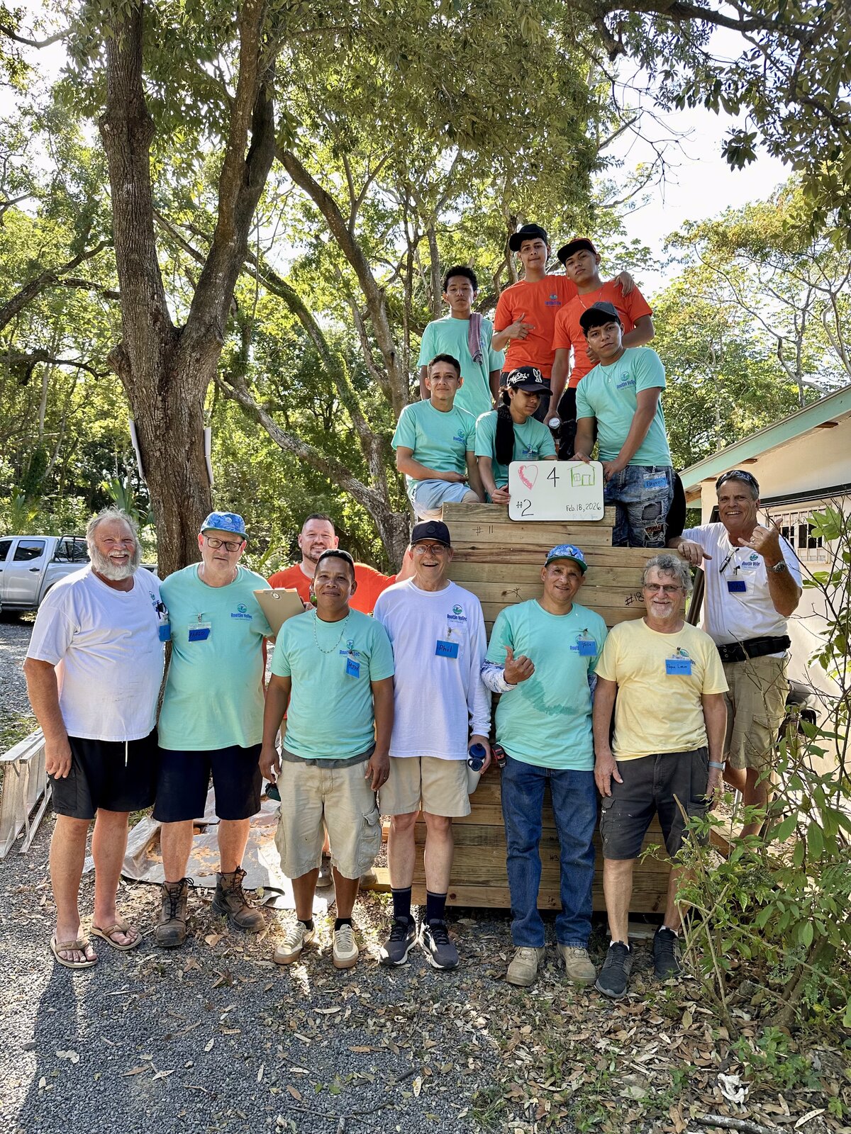 Missions team and students in front of completed wall panels ready to build a home